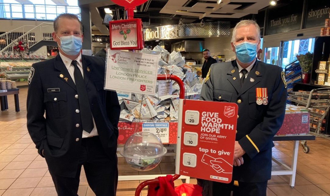 Officers standing at a Christmas Kettle.
