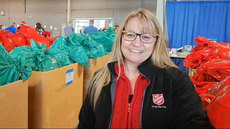 Nancy standing among bags of toys.