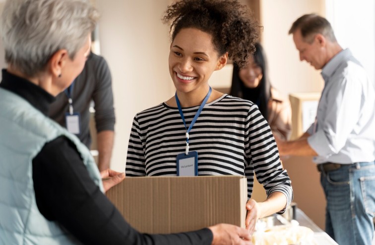 Woman donating box of goods to staff